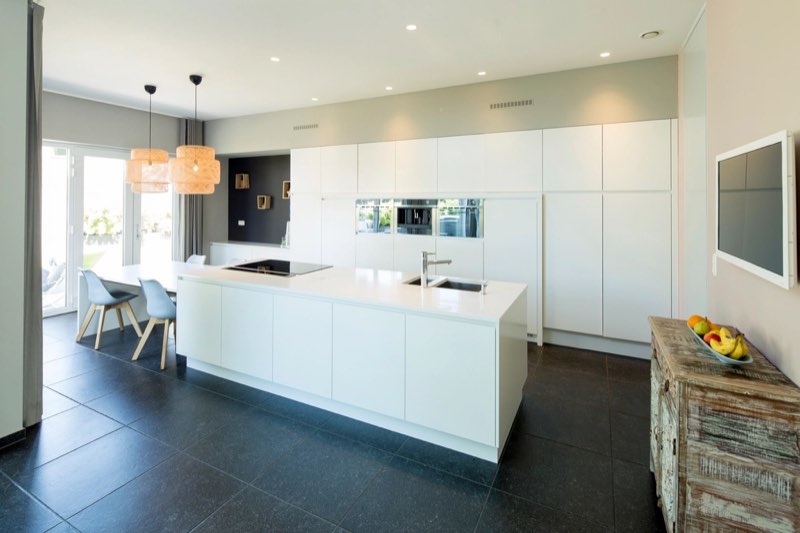 A bright, uncluttered kitchen with clear counters and a mopped floor.